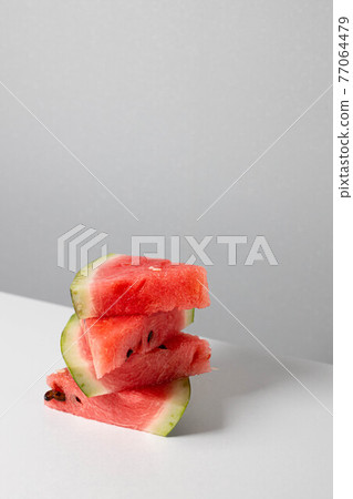 A bunch of triangular pieces of watermelon on the table. Vertical orientation A bunch of triangular pieces of watermelon on the table. Vertical orientation 77064479