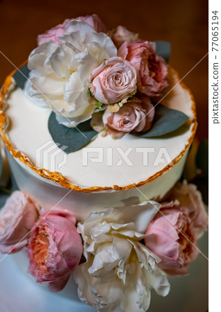 white cake decorated with live flowers. Traditional wedding cake. white cake decorated with live flowers. Traditional wedding cake. 77065194