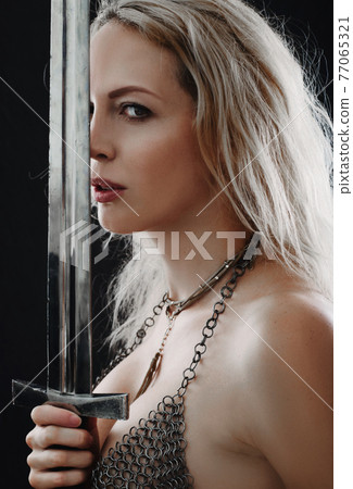 Beautiful blong viking woman holding sword blade Beautiful blong viking woman holding sword blade 77065321