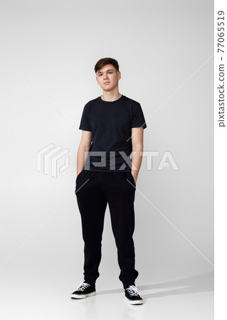 Handsome guy in black t-shirt looking into camera 77065519
