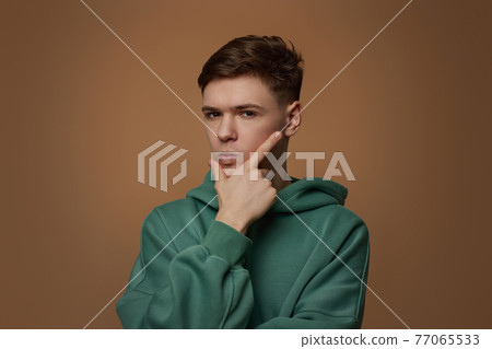 handsome guy touch his chin by hand thinking handsome guy touch his chin by hand thinking 77065533