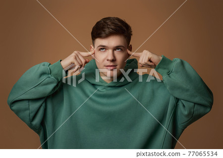 young handsome guy touch his chin by hand thinking young handsome guy touch his chin by hand thinking 77065534