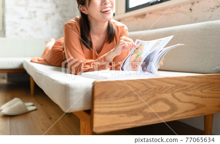 A woman reading a magazine 77065634