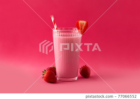 Strawberry milkshake in glass on pink background Strawberry milkshake in glass on pink background 77066552