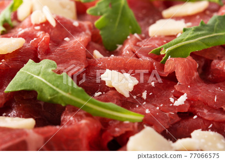 Marbled beef carpaccio on black plate isolated on white background Marbled beef carpaccio on black plate isolated on white background 77066575