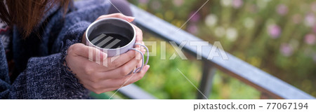 solo woman drink coffee with relax and wellbeing feel with mountain background 77067194