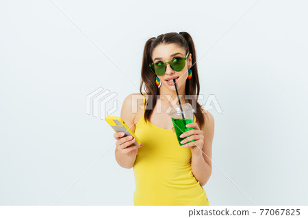 Beautiful cunning young woman wearing yellow summer top and green sunglasses 77067825