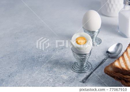 Breakfast of two hard-boiled eggs and toast. Breakfast of two hard-boiled eggs and toast. 77067910