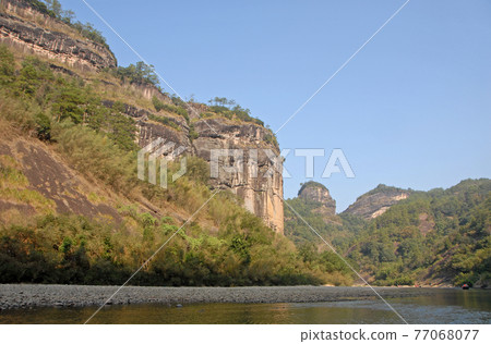 Wuyishan mountains in Fujian Province, China. View of the scenic Wuyi mountains from a raft on the Nine Bends River or Nine Twists Stream. Wuyi mountains are a UNESCO site in China. 77068077