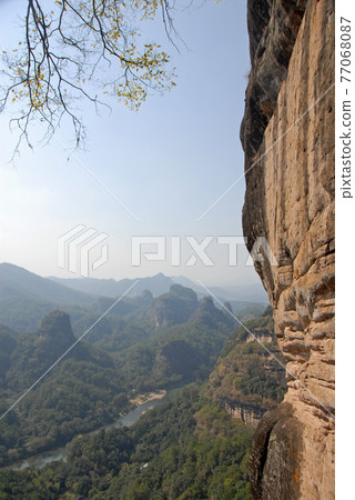 Wuyishan mountains in Fujian Province, China. On the path to DaWang (Great King) Peak. View over the mountains with Nine Bends River or Nine Twists Stream below. Wuyishan is a UNESCO site in China. 77068087
