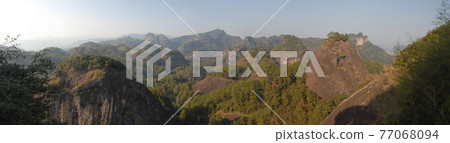 Wuyishan mountains in Fujian Province, China. Scenic view over the peaks of Wuyi mountains. A panoramic view of the hills from Roaring Tiger Rock. Wuyishan is a UNESCO World Heritage site in China. 77068094