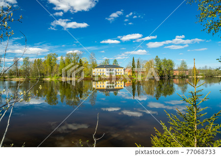 Kouvola, Finland - May 16, 2019: Beautiful wooden Rabbelugn Manor - Takamaan Kartano. Wrede family house was built in 1820 on the river Kymijoki bank. Kouvola, Finland - May 16, 2019: Beautiful wooden Rabbelugn Manor - Takamaan Kartano. Wrede family house was built in 1820 on the river Kymijoki bank. 77068733