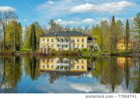 Kouvola, Finland - May 16, 2019: Beautiful wooden Rabbelugn Manor - Takamaan Kartano. Wrede family house was built in 1820 on the river Kymijoki bank. Kouvola, Finland - May 16, 2019: Beautiful wooden Rabbelugn Manor - Takamaan Kartano. Wrede family house was built in 1820 on the river Kymijoki bank. 77068741