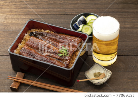 木紋桌上放著閃亮的鰻魚和啤酒 木紋桌上放著閃亮的鰻魚和啤酒 77069155