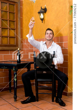 Flamenco dancer from Seville in Spain drinking a wine before dancing in a typical Spanish venue 77069212