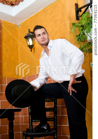 Flamenco dancer from Seville in Spain drinking a wine before dancing in a typical Spanish venue Flamenco dancer from Seville in Spain drinking a wine before dancing in a typical Spanish venue 77069215