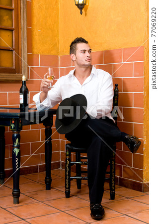 Flamenco dancer from Seville in Spain drinking a wine before dancing in a typical Spanish venue Flamenco dancer from Seville in Spain drinking a wine before dancing in a typical Spanish venue 77069220