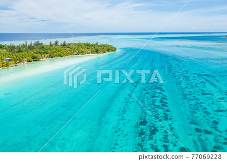 Climate change an Rising sea levels concept photo French Polynesia. Global warming and rising sea levels are a threat to Huahine depicted in image, Tahiti and other island nations. Travel destination. 77069228