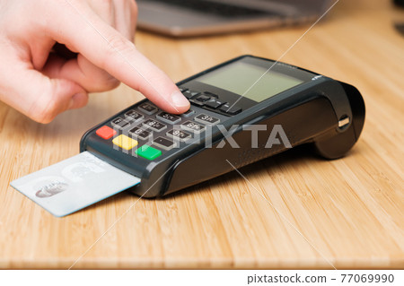 Man hand enters pin code on the terminal for payment. Man hand enters pin code on the terminal for payment. 77069990