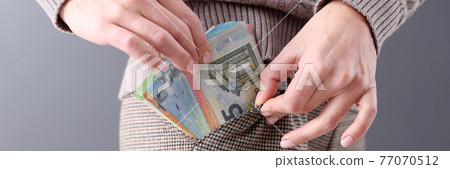 Woman pulling out lot of euros in cash from her pocket closeup 77070512