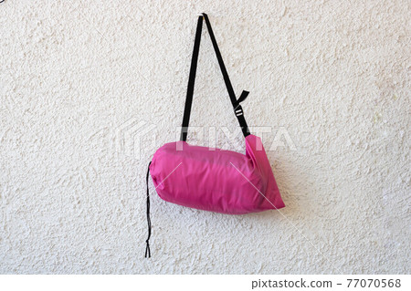 Pink sports bag with a black belt on a white rough background Pink sports bag with a black belt on a white rough background 77070568