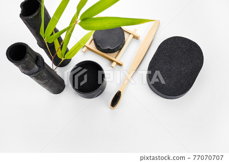 Skin and tooth cleansing and detox. Bamboo charcoal powder cosmetics on white background Skin and tooth cleansing and detox. Bamboo charcoal powder cosmetics on white background 77070707