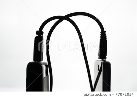A cell phone charging A cell phone charging 77071034