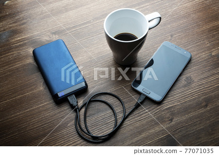 A cell phone charging A cell phone charging 77071035