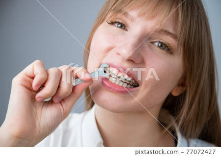 The woman jokingly tightens the wire of the brakes with a wrench. Bite correction device 77072427