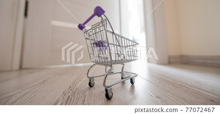 Grocery cart at the open door. Delivery of products. Mini trolley for contactless delivery. Grocery cart at the open door. Delivery of products. Mini trolley for contactless delivery. 77072467
