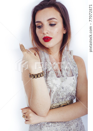 young pretty lady in fashion style rich jewelry and dress wearing bright party make up posing on white background isolated, lifestyle people concept 77072871