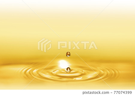Macro background of sparkling water droplets and ripples on gold leaf for beauty and body care. 77074399