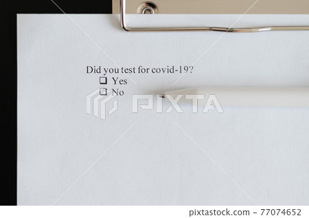 Coronavirus test questionnaire and pen on the table. Checklist for questions about covid-19. 77074652