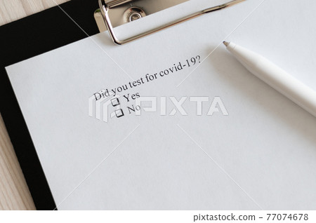 Coronavirus test questionnaire and pen on the table. Checklist for questions about covid-19. 77074678