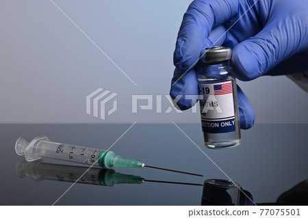 Gloved Hand Takes American Covid-19 Vaccine Jar Gloved Hand Takes American Covid-19 Vaccine Jar 77075501