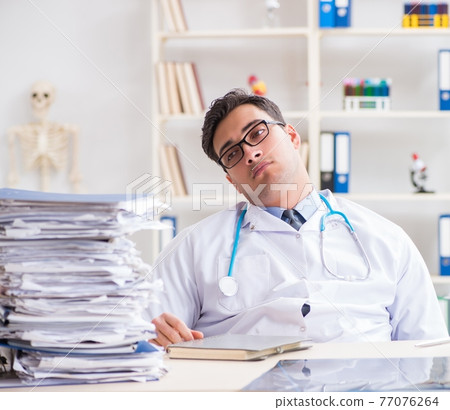 Busy doctor with too much work in hospital Busy doctor with too much work in hospital 77076264