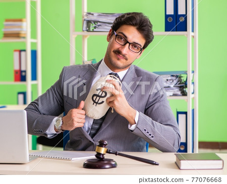 Young handsome lawyer working in the office 77076668
