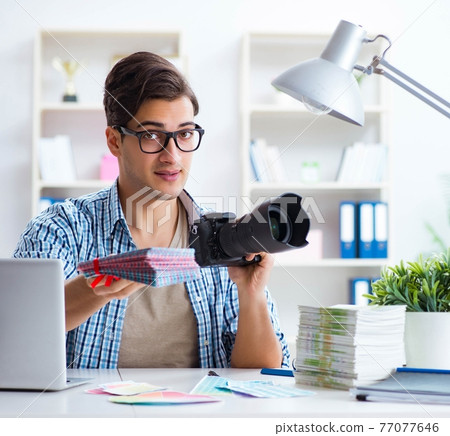 Young photographer working with his camera Young photographer working with his camera 77077646