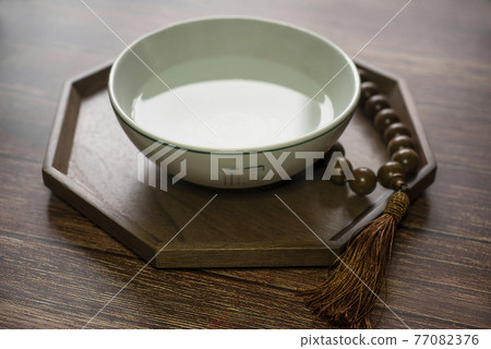 A traditional Korean practice of praying to God with purified water and prayer beads 77082376