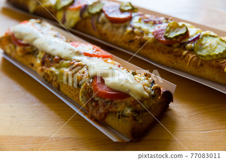 Polish zapiekanka toasted baguette with cheese and vegetables Polish zapiekanka toasted baguette with cheese and vegetables 77083011