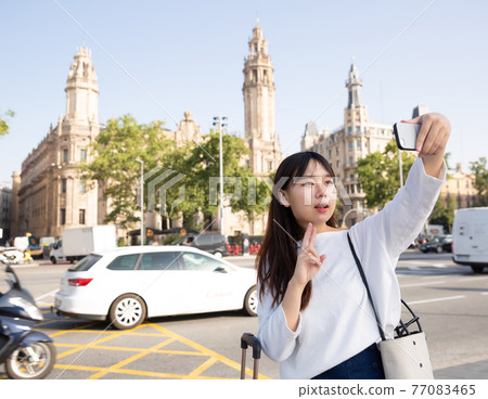 Pretty chinese female tourist making selfie on the background of landmark Pretty chinese female tourist making selfie on the background of landmark 77083465
