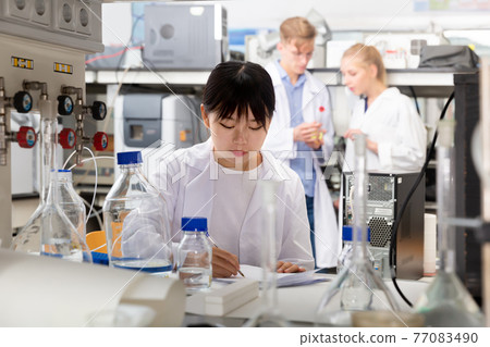 Casual Chinese female student noting results Casual Chinese female student noting results 77083490