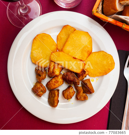 Fried pork meat pieces with baked potatoes Fried pork meat pieces with baked potatoes 77083665
