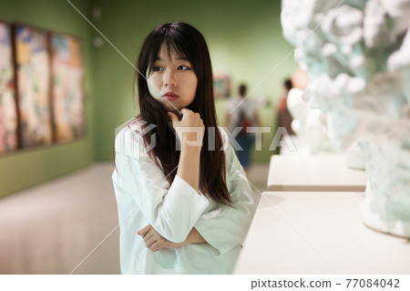 Chinese woman looking at exhibition in museum of sculpture Chinese woman looking at exhibition in museum of sculpture 77084042