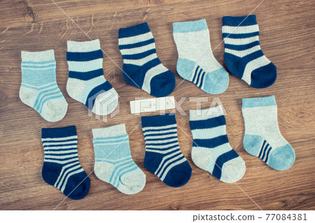 Clothing for newborn and pregnancy test showing positive result, concept of expecting for baby Clothing for newborn and pregnancy test showing positive result, concept of expecting for baby 77084381
