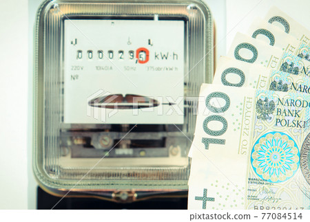 Polish currency money and and electric energy meter old electromechanical type in background Polish currency money and and electric energy meter old electromechanical type in background 77084514
