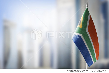 A small flag of South Africa on the background of a blurred background A small flag of South Africa on the background of a blurred background 77086244