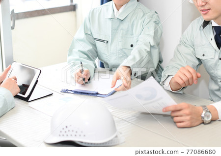 Men and women in work clothes having a meeting in the office 77086680