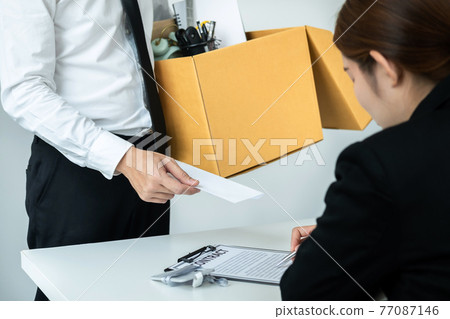 Business man employee holding brown cardboard box and sending a letter of resignation to the executive 77087146
