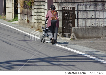 Take a walk in a silver car and an elderly person 77087372